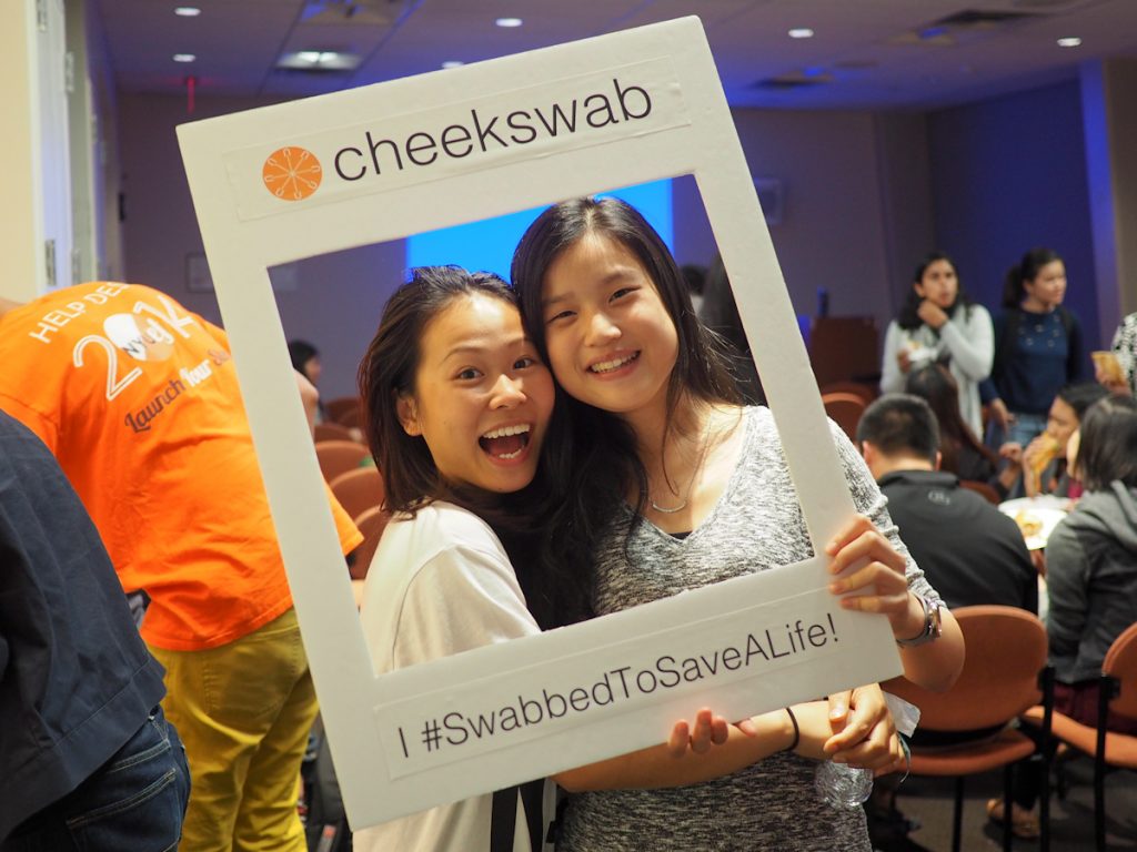 Two East Asian women smiling into Cheekswab frame